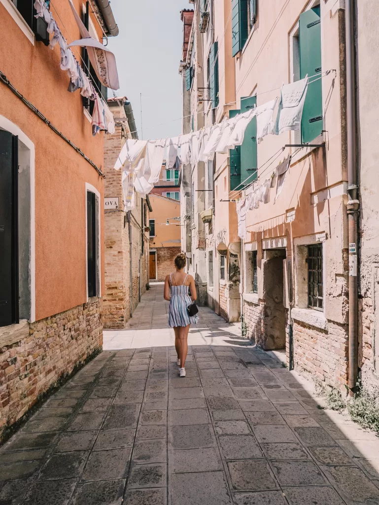 Girl in blue and white sundress walking along the streets of Europe.