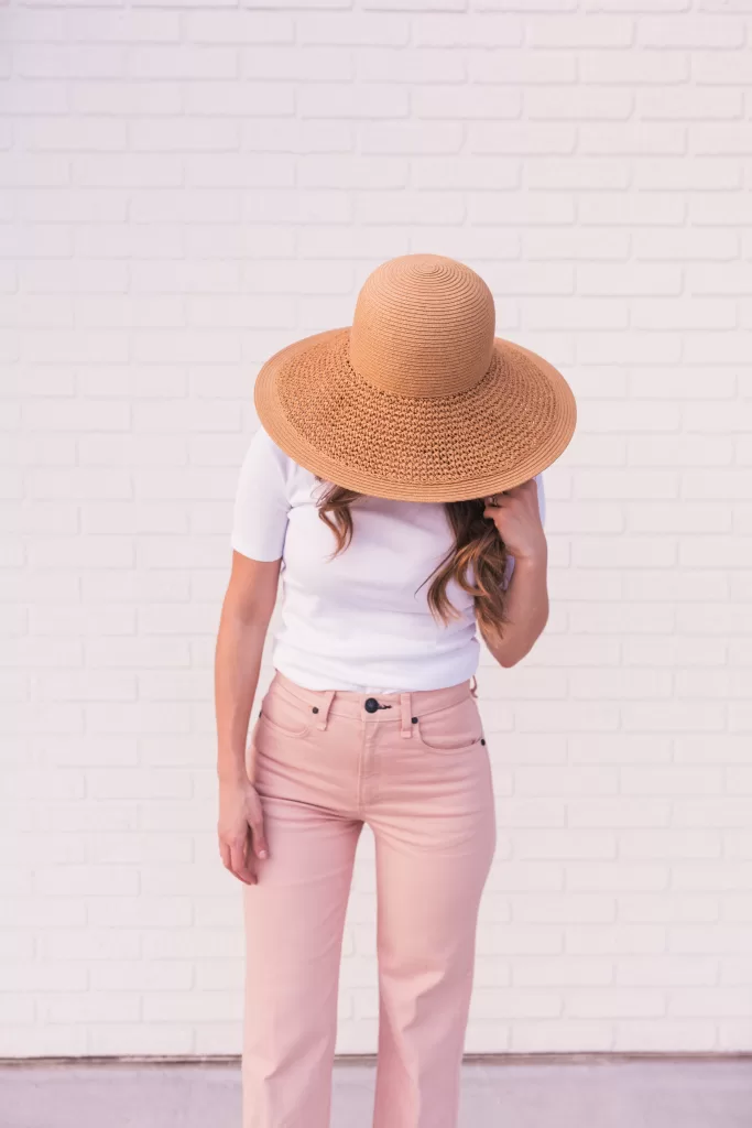 Summer outfit with a fitted shirt, blush pants, and straw hat. European spring outfit. European fashion. #eauropeanaesthetic #travelaesthetic #traveloutfit #Europeansummer2023 #Europeansummeroutfit2023 #europeansummerpackinglist2023