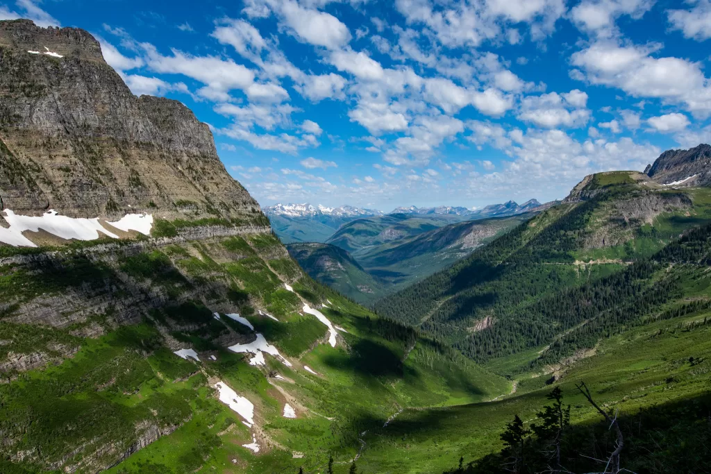 Going to The Sun Road from the Highline Trail in Glacier National Park and the valley beneath it. The clouds are small and fluffy during bright sunshine. #TheLoopandGardenWall #GlacierNationalPark #TheHighlineTrail #Montana #Hiking #Hikingtrails
